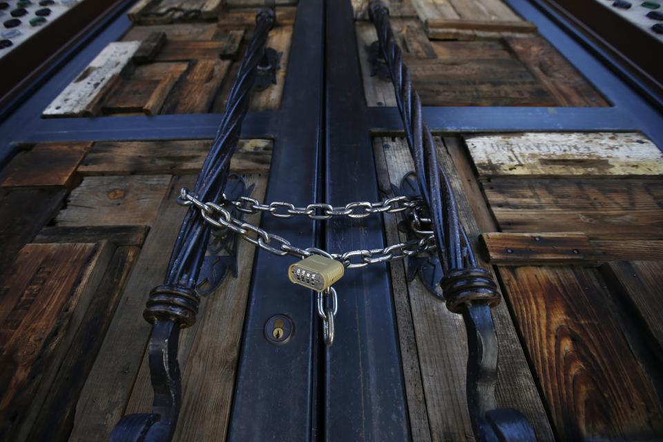 Bottled Blonde, one of the many restaurant bars closed for the next 30 days due to the surge in coronavirus cases, is padlocked shut Tuesday, June 30, 2020, in Scottsdale, Ariz. (AP Photo/Ross D. Franklin)