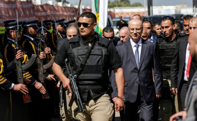 Palestinian Prime Minister Rami Hamdallah, escorted by bodyguards, is greeted by police forces of the Islamist Hamas movement upon his arrival in Gaza City on March 13, 2018