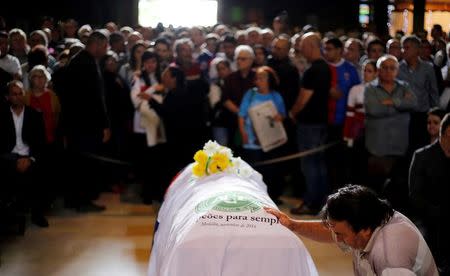 A soccer fan pays tribute next to the coffin of Chapecoense club head coach Caio Junior, who died in the plane crash in Colombia, during a ceremony in Curitiba, Brazil, December 4, 2016. REUTERS/Rodolfo Buhrer