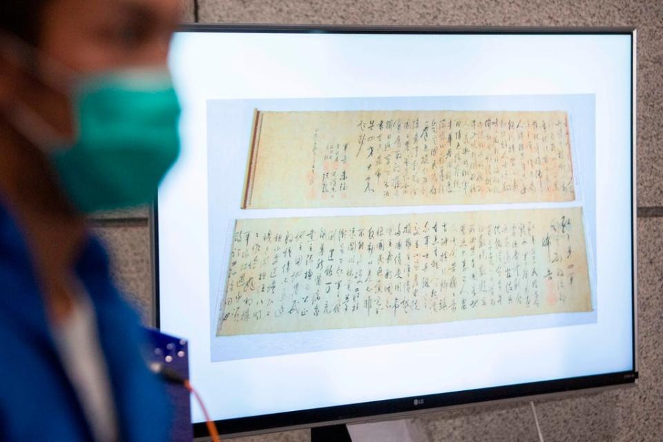 Police show a picture of a calligraphy scroll written by Mao Zedong worth about 300 million USD, that had been recovered but found chopped in half at a press conference in Hong Kong (AFP via Getty Images)