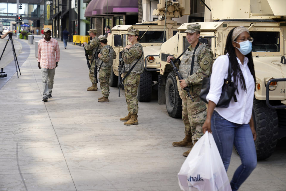 Minnesota National Guard soldiers stand watch along the famous Nicollet Mall Thursday, Aug. 27, 2020, in downtown Minneapolis. An emergency curfew expired and downtown Minneapolis was calm Thursday morning after a night of unrest that broke out following what authorities said was misinformation about the suicide of a Black homicide suspect. (AP Photo/Jim Mone)