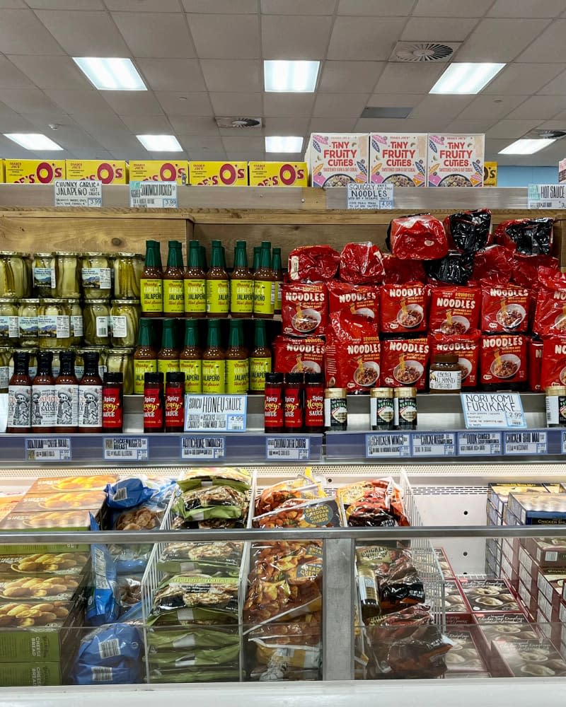 Commack, NY, USA, 7.20.23 - Snack, cookies, and frozen food in an aisle at Trader Joe's. A sign says Appetizers Right Here with an arrow pointing down.