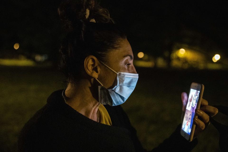 In this photo taken on Friday, April 10, 2020 nurse Cristina Settembrese makes a video call to say goodnight to her parents near her home in Basiglio, Italy after her work shift in the COVID-19 ward at the San Paolo hospital in Milan. (AP Photo/Luca Bruno)