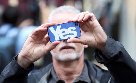 A 'Yes' campaigner takes a photograph with his smart phone during a rally in Glasgow, Scotland September 17, 2014. REUTERS/Paul Hackett