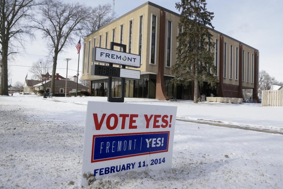 In this Thursday, Feb. 6, 2014 photo, a yard sign urging voters to vote "Yes" is seen in front of City Hall in Fremont, Neb. Voters in the eastern Nebraska city of Fremont will decide in a special election on Tuesday, Feb. 11, whether to drop housing restrictions aimed at reducing illegal immigration they had approved in 2010. The city leaders scheduled the special election because of concerns the housing restrictions could cost them millions in federal grants and lead to more lawsuits against the city. (AP Photo/Nati Harnik)