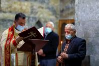 A priest Father Ammar Altony Yako leads the prayers as Iraqi Christians attend a mass at the Grand Immaculate old Church in Qaraqosh