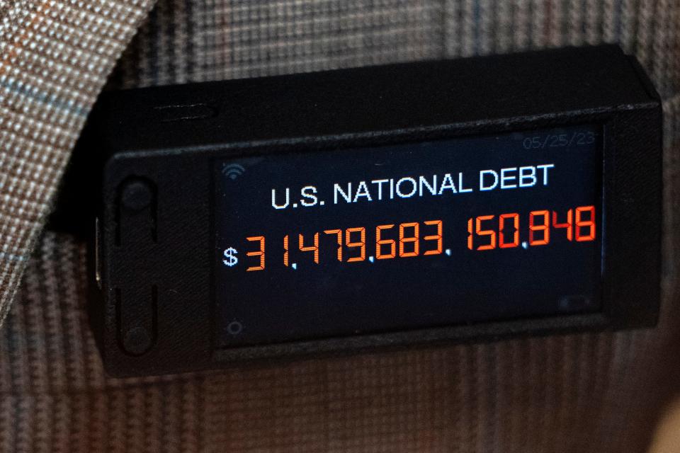 Rep. Thomas Massie, R-Ky., a member of the conservative House Freedom Caucus, wearing a digital pin simulating the increasing U.S. National Debt, attends a House Rules Committee meeting to prepare the debt limit bill, The Fiscal Responsibility Act of 2023, for a vote on the floor, at the Capitol in Washington, Tuesday, May 30, 2023. (AP Photo/Jacquelyn Martin)