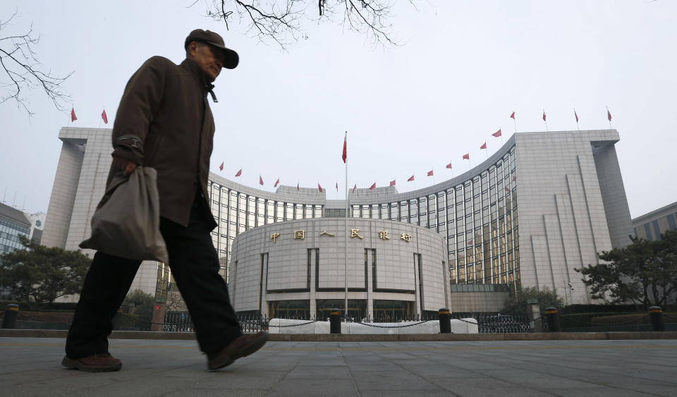 An elderly Chinese man walks past the headquarters of the People's Bank of China (PBOC) in Beijing, China, Tuesday, March 11, 2014. China's central bank governor Zhou Xiaochuan said Beijing might finish the process of easing controls on interest rates within two years and market forces will set the pace for allowing use of its tightly controlled currency abroad. (AP Photo/Vincent Thian)