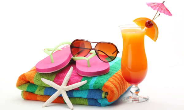 Beach accessories with swimming suit and tequila sunrise cocktail on white background.