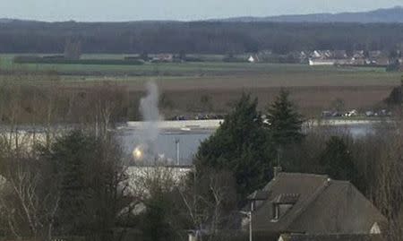 A flash of light and smoke appear, in this video grab, at the start of the final assault at the scene of a hostage taking at an industrial zone in Dammartin-en-Goele, northeast of Paris January 9, 2015. REUTERS/Reuters TV