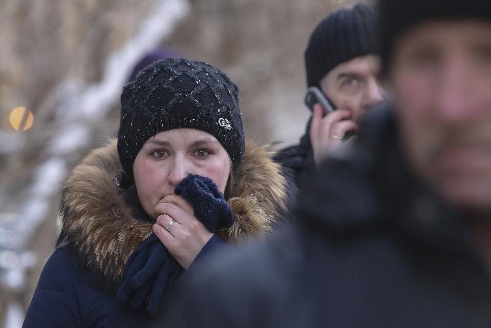 A woman reacts as she stands at the scene of the collapsed apartment building in Magnitogorsk, a city of 400,000 people, about 1,400 kilometers (870 miles) southeast of Moscow, Russia, Wednesday, Jan. 2, 2019. Search crews have pulled more bodies from a huge pile of rubble at a collapsed Russian apartment building. The building's pre-dawn collapse on Monday came after an explosion that was believed to have been caused by a gas leak. (AP Photo/Maxim Shmakov)