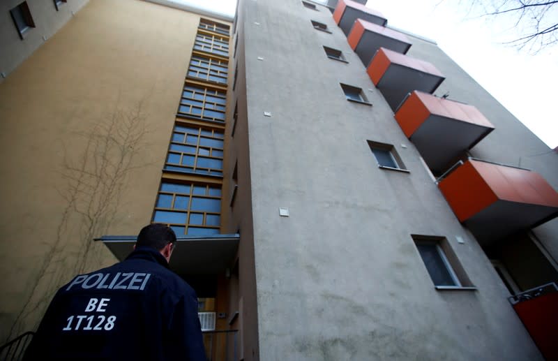 A police officer is seen outside the house of a Syrian man suspected of exchanging bomb building material that was arrested earlier today in Berlin