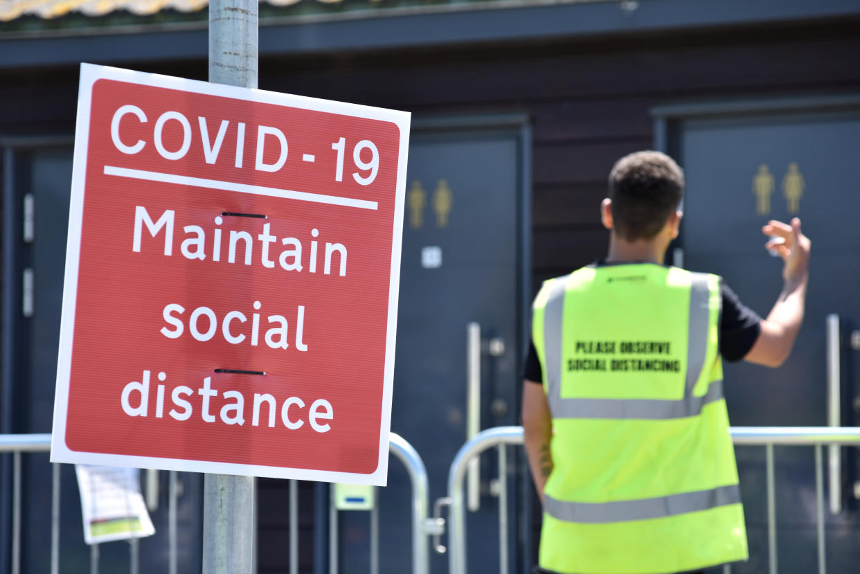 SOUTHEND-ON-SEA, ENGLAND - MAY 25: An official controls the use of public toilets by calling people from the queue and guiding them to a numbered cubicle as crowds of people gather on the beach on a warm and sunny May Day bank holiday on May 25, 2020 in Southend-on-Sea, United Kingdom. The British government has started easing the lockdown it imposed two months ago to curb the spread of Covid-19, abandoning its 'stay at home' slogan in favour of a message to 'be alert', but UK countries have varied in their approaches to relaxing quarantine measures. (Photo by John Keeble/Getty Images)