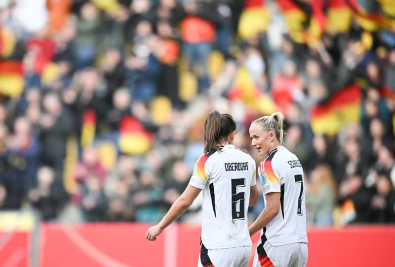 Germany's Lena Oberdorf (L) and Lea Schueller talk during the UEFA Women's Euro 2025 qualifying soccer match between Germany and Iceland in Aachen. Sebastian Christoph Gollnow/dpa