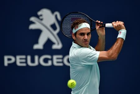 Mar 31, 2019; Miami Gardens, FL, USA; Roger Federer of Switzerland returns a shot back to John Isner of the United States during the men's finals at Miami Open Tennis Complex. Steve Mitchell-USA TODAY Sports