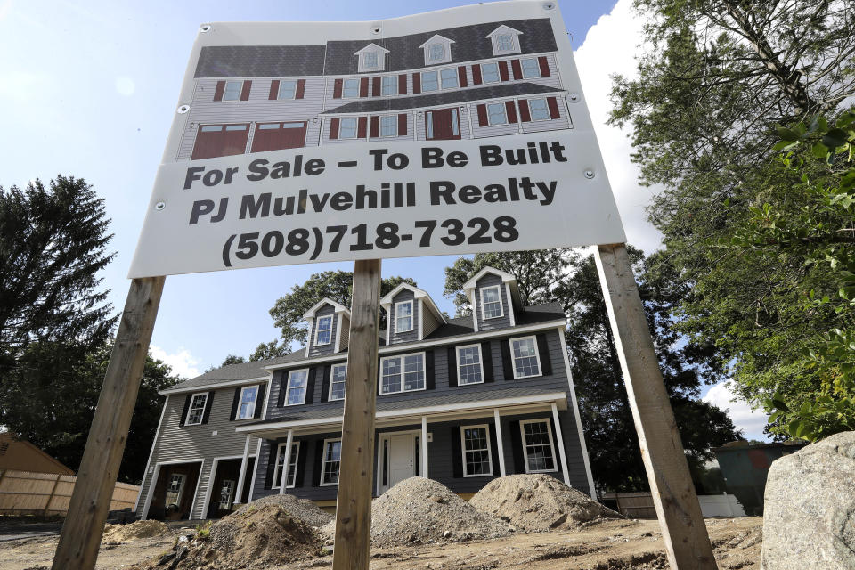 In this Sept. 3, 2019 photo a for sale sign, top, rests in front of a newly constructed home, in Norwood, Mass. On Thursday, Oct. 17, the Commerce Department reports on U.S. home construction in September. (AP Photo/Steven Senne)