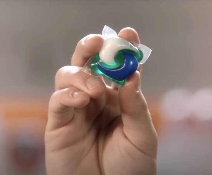 hand holding a square tide pod package