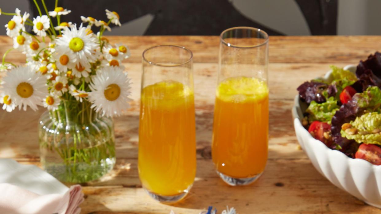 a plate of quiche lorraine and glasses of juice on a table