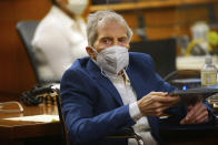 Robert Durst holds a device to read the real time spoken script as he appears in the courtroom of Judge Mark E. Windham as attorney's begin opening statements in the trial of the real estate scion charged with murder of longtime friend Susan Berman, at Los Angeles County Superior Court, Tuesday, May 18, 2021, in Inglewood, Calif. Durst's murder trial was delayed more than a year due to the Covid-19 pandemic. (Al Seib/Los Angeles Times via AP, Pool)