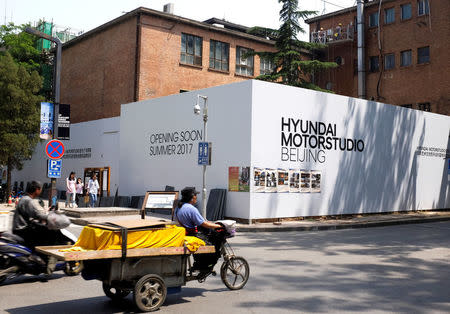 A tricycle drives past the construction site of the Hyundai Motor Studio in Beijing, China, May 27, 2017. Picture taken May 27, 2017. REUTERS/Thomas Peter