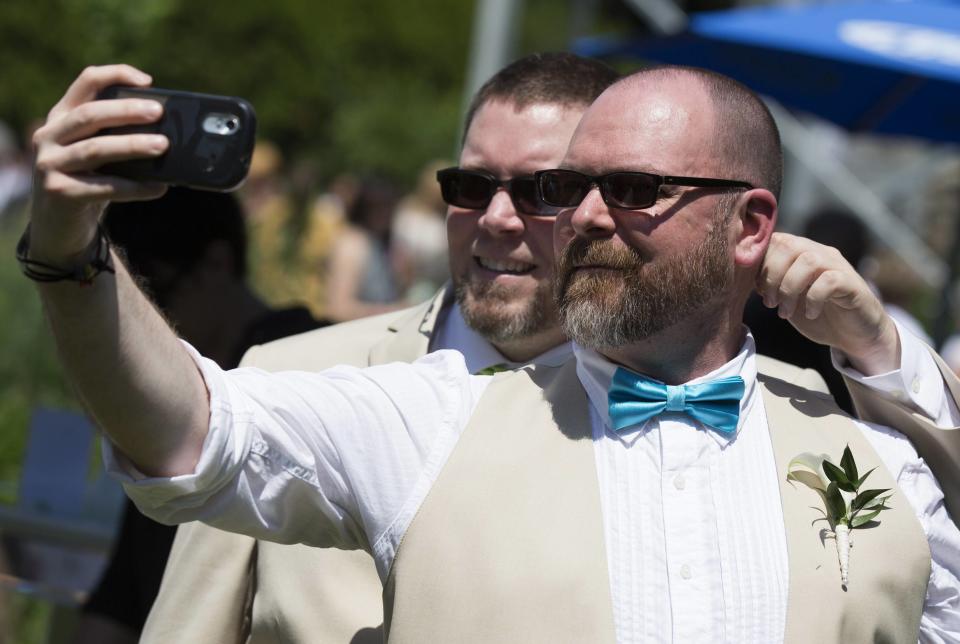 A couple takes a selfie before "The Celebration of Love", a grand wedding where over 100 LGBT couples will get married, at Casa Loma in Toronto