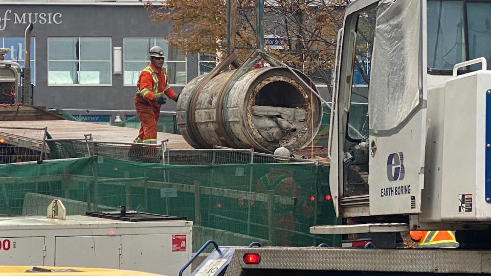 The rear section of a micro tunnel boring machine that was trapped underground in west Toronto since spring 2022 is lifted onto a flatbed truck after being freed.