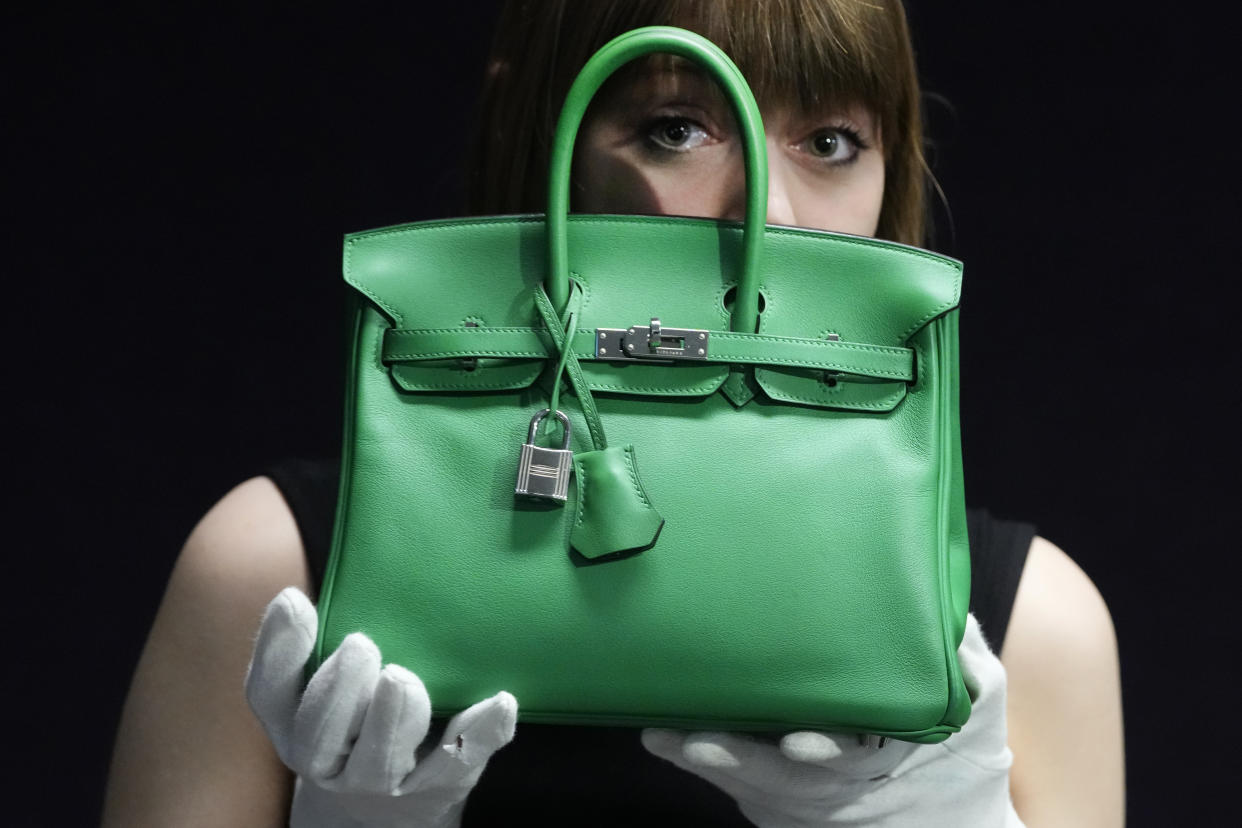 A Bonhams employee displays a Hermes: a Bambou Swift Leather Birkin 25 bag, at the auction rooms in London, Monday, Feb. 26, 2024. The bag estimated at 12,000-18,000 UK Pounds (15,000-22,800 US Dollars) will be for auction in the live sale on Feb. 28, it will feature luxurious items of handbags and ready-to-wear designs from coveted names including Chanel, Hermes, Karl Lagerfeld for Chanel, Christian Dior, Louis Vuitton, and Gucci. (AP Photo/Kirsty Wigglesworth)