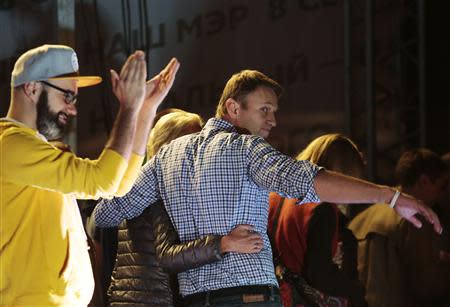 Russian opposition leader Alexei Navalny (C) and his wife Yulia leave the stage during a rally in Moscow, September 9, 2013. REUTERS/Tatyana Makeyeva