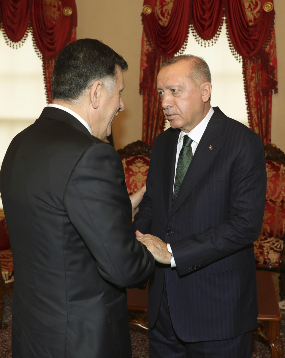 Turkey's President Recep Tayyip Erdogan, right, shakes hands with Fayez al Sarraj, the head of Libya's internationally-recognized government, prior to their meeting in Istanbul, Sunday, Jan. 12, 2020. The meeting at Dolmabahce Palace took place on the first day of a ceasefire in Libya initiated by Turkey and Russia. (Turkish Presidency via AP, Pool)