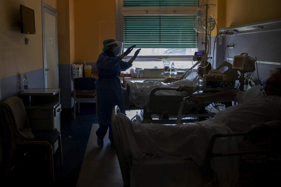 In this photo taken on Friday, April 10, 2020 nurse Cristina Settembrese gestures to a patient during her work shift in the COVID-19 ward at the San Paolo hospital in Milan, Italy. (AP Photo/Luca Bruno)