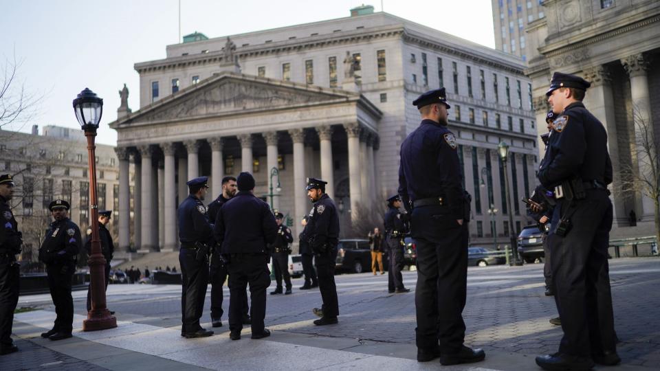 New York Police officers wait for instructions around the courthouse ahead of former President Donald Trump's anticipated indictment on Tuesday, March 21, 2023, in New York. A New York grand jury investigating Trump over a hush money payment to a porn star appears poised to complete its work soon as law enforcement officials make preparations for possible unrest in the event of an indictment. (AP Photo/Eduardo Munoz Alvarez)