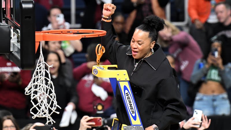 South Carolina head coach Dawn Staley celebrates as she prepares to cut down the net after defeating Oregon State in an Elite Eight round college basketball game during the NCAA Tournament, Sunday, March 31, 2024, in Albany, N.Y.