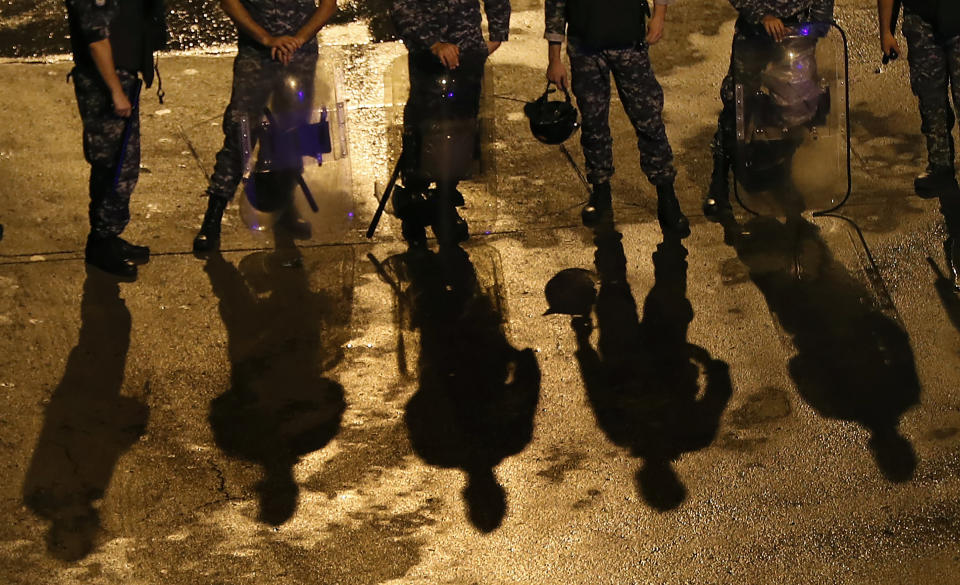 Lebanese riot policemen stand guard on a road leading to the government palace, in Beirut, Lebanon, Wednesday, Oct. 23, 2019. Lebanese troops moved in to open major roads in Beirut and other cities Wednesday, scuffling in some places with anti-government protesters who had blocked the streets for the past week, grinding the country to a halt. (AP Photo/Hussein Malla)