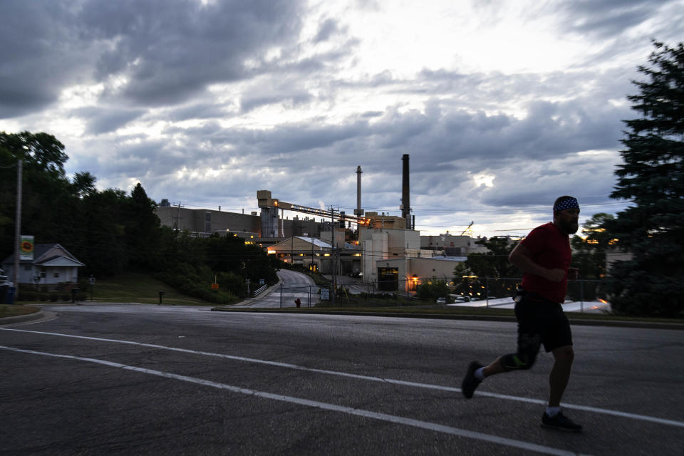 CORRECTS CITY TO COMBINED LOCKS, WIS. A jogger runs past the Midwest Paper Group mill in Combined Locks, Wis., part of the greater Appleton area, Monday, Aug. 17, 2020. By almost any measure, President Donald Trump's promises of an economic revival in places like Appleton have gone unfulfilled. The area has lost about 8,000 jobs since he got elected. The state that is vital for Trump's victory had more jobs a decade ago when the country was still ailing from the Great Recession than it did in July.(AP Photo/David Goldman)