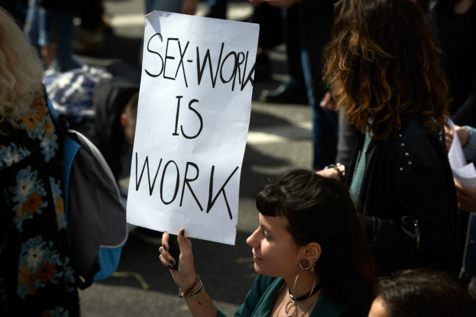 Someone holds up a sign that says "Sex Work is Work" during International Women's Day in Toulouse, France