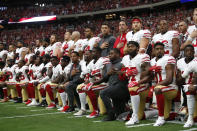 The San Francisco 49ers kneel and stand in solidarity on the sideline, during the anthem, prior to the game against the Arizona Cardinals at the University of Phoenix Stadium on October 1, 2017 in Phoenix, Arizona. The Cardinals defeated the 49ers 18-15. (Photo by Michael Zagaris/San Francisco 49ers/Getty Images)