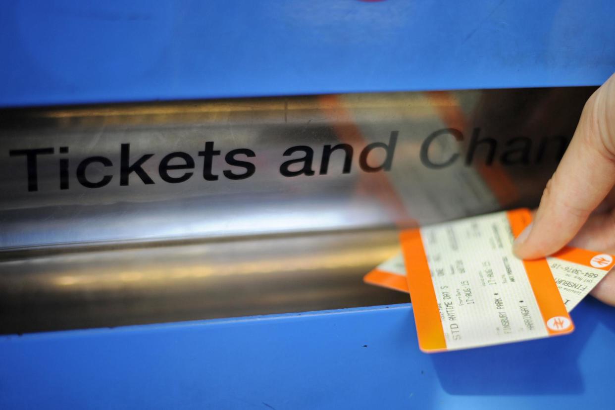 A person buying a train ticket at Finsbury Park station: PA