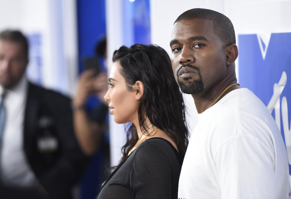 Kanye West, right, seen here with his wife, Kim Kardashian, is under fire for his wacky explanation of why his Yeezy Slides appeared to be too small at 2 Chainz’s wedding. (Photo by Evan Agostini/Invision/AP, File)