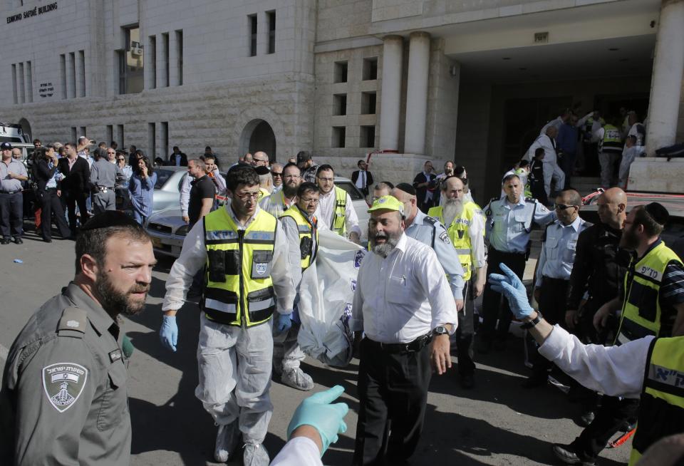 Israeli emergency personnel carry a covered body from the scene of an attack at a Jerusalem synagogue