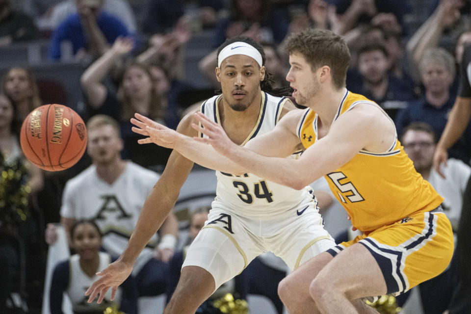 Kent State's Mike Bekelja passes in front of Akron's Nate Johnson (34) during the first half of an NCAA college basketball game in the championship of the Mid-American Conference tournament, Saturday, March 16, 2024, in Cleveland. (AP Photo/Phil Long)