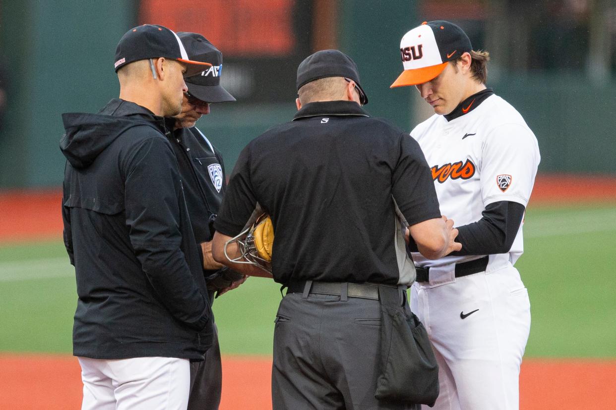 Umpires check Oregon State pitcher Aiden May's glove (24) for potential enhancements during an NCAA college baseball game at Goss Stadium on Friday, April 26, 2024, in Corvallis, Ore.