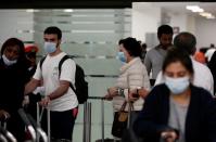 People wearing a protective face masks arrive on an Emirates flight at Benito Juarez international airport in Mexico City