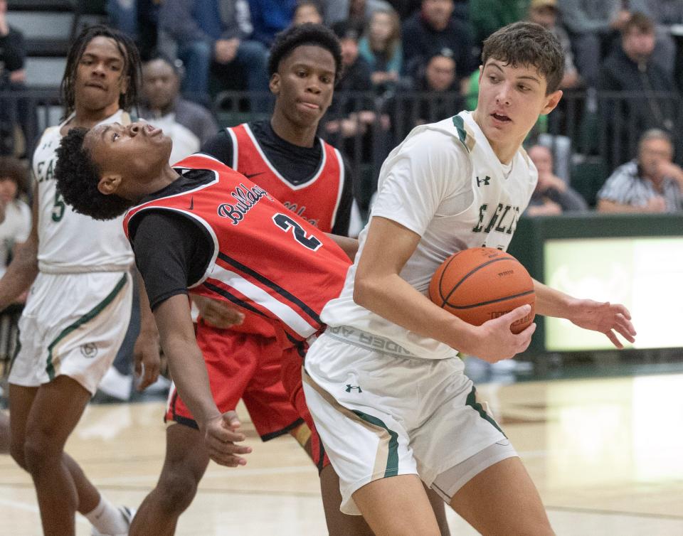 McKinley's Anthony Chavers (2) falls back as he defends GlenOak's Reese Zerger at GlenOak on Thursday. December 14, 2023.