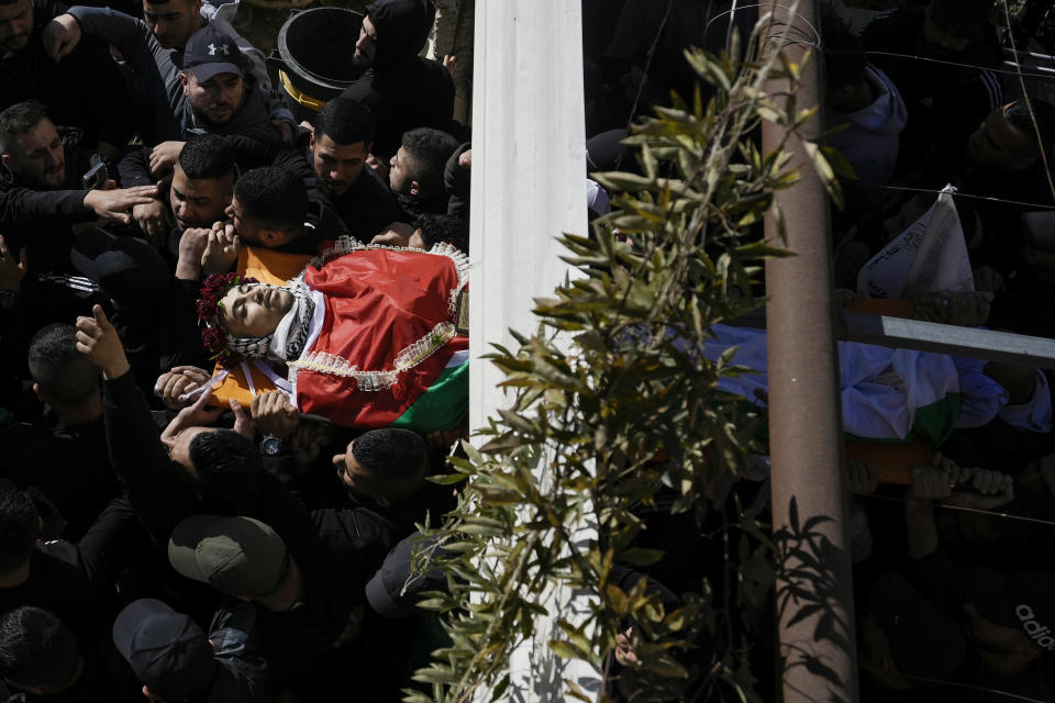 Palestinian mourners carry the body of Yusef Muhaisen during his funeral in the West Bank town of al Ram, north of Jerusalem, Friday, Jan. 27, 2023. Muhaisen, 22, was killed during clashes with Israeli troops. (AP Photo/Majdi Mohammed)