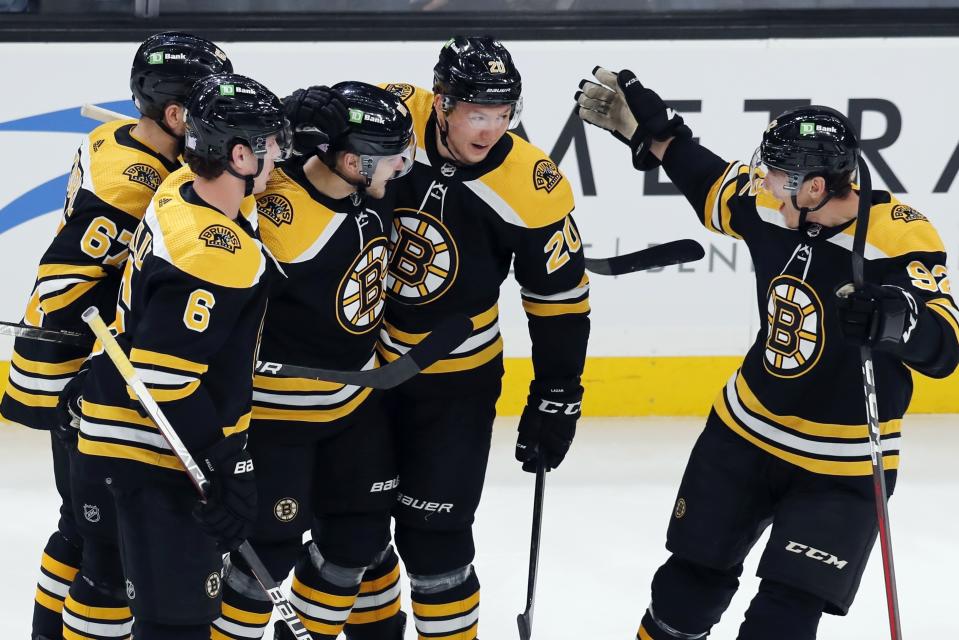 Boston Bruins' Anton Blidh, center left, celebrates his goal with teammates Mike Reilly (6), Jakub Zboril (67) Curtis Lazar (20) and Tomas Nosek (92) during the first period of an NHL hockey game against the Vancouver Canucks, Sunday, Nov. 28, 2021, in Boston. (AP Photo/Michael Dwyer)