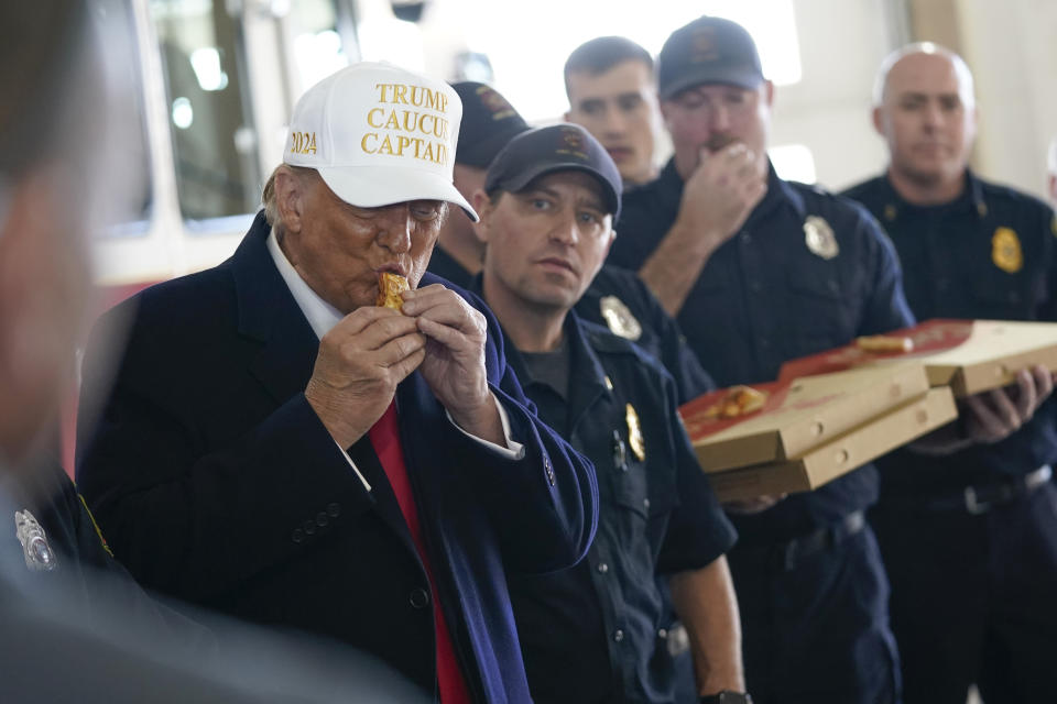 Republican presidential candidate former President Donald Trump eats pizza with fire fighters at Waukee Fire Department in Waukee, Iowa, Sunday, Jan. 14, 2024. (AP Photo/Andrew Harnik)