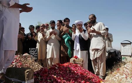 Friends and relatives pray over the grave of Abdul Rashid, a lawyer killed during the blast outside the Civil Hospital, as he is buried at the graveyard in Quetta, Pakistan August 9, 2016. REUTERS/Naseer Ahmed