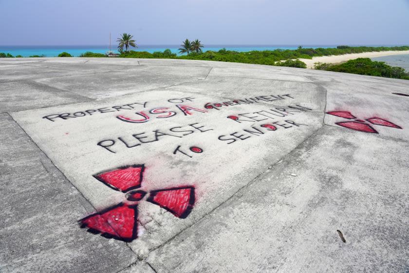 Graffiti rests on Runit Dome, in Enewetak Atoll of the Marshall Islands, urging the United States to take responsibility for the radioactive waste encapsulated inside the structure, on May 25, 2018. Although the U.S. government has refused to clean up waste from the dome, which is leaking into surrounding waters, it later paid for a contractor to remove the graffiti from the dome's surface.