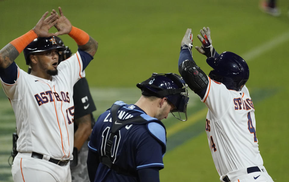 Houston Astros George Springer celebrates with teammate Martin Maldonado after hitting a two run home run against the Tampa Bay Rays during the fifth inning in Game 4 of a baseball American League Championship Series, Wednesday, Oct. 14, 2020, in San Diego. At center is Tampa Bay Rays catcher Mike Zunino. (AP Photo/Ashley Landis)