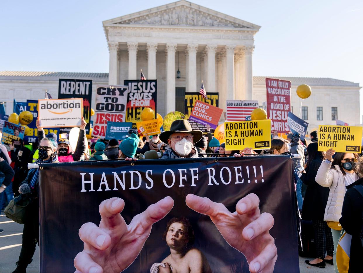 Abortion rights advocates and anti-abortion protesters demonstrate in front of the U.S. Supreme Court, Wednesday, Dec. 1, 2021, in Washington, as the court hears arguments in a case from Mississippi, where a 2018 law would ban abortions after 15 weeks of pregnancy, well before viability.